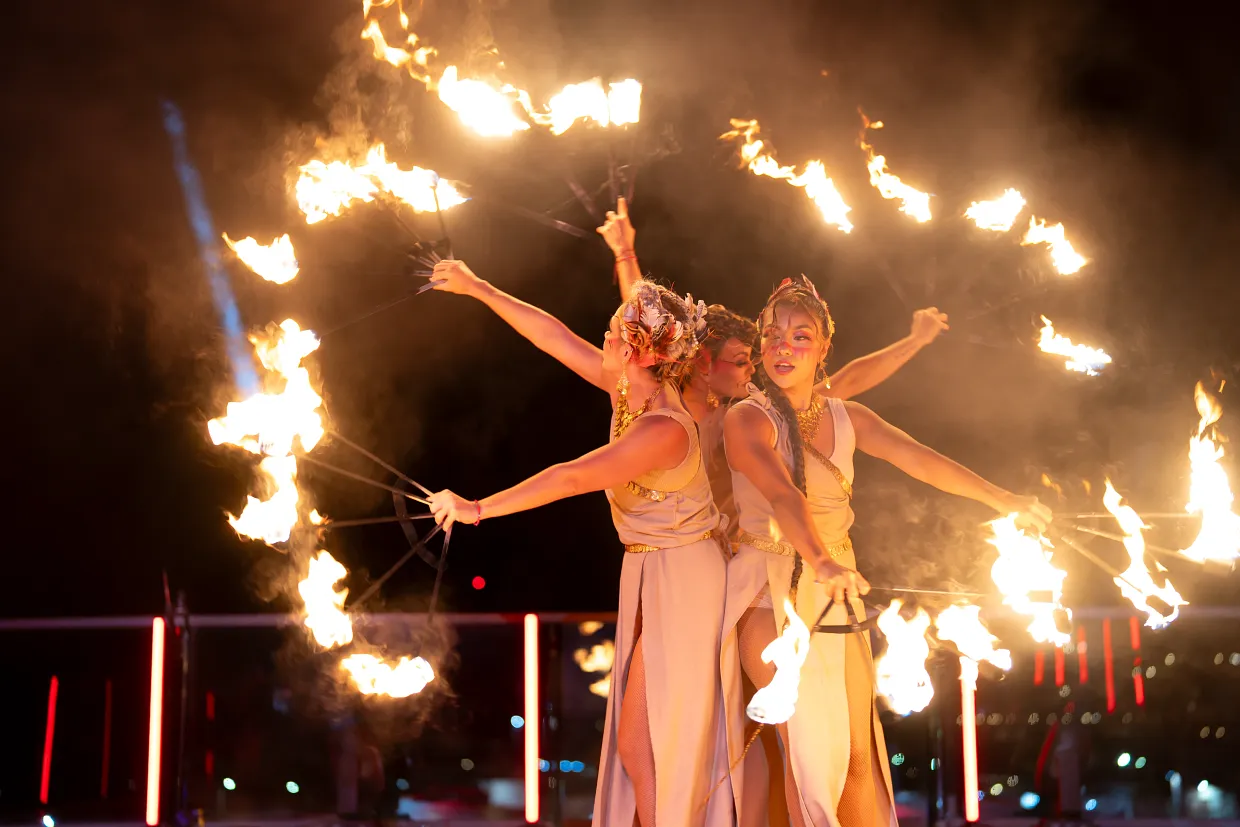 Nighttime fire performance at Breathless Cabo San Lucas with entertainers spinning flaming props.