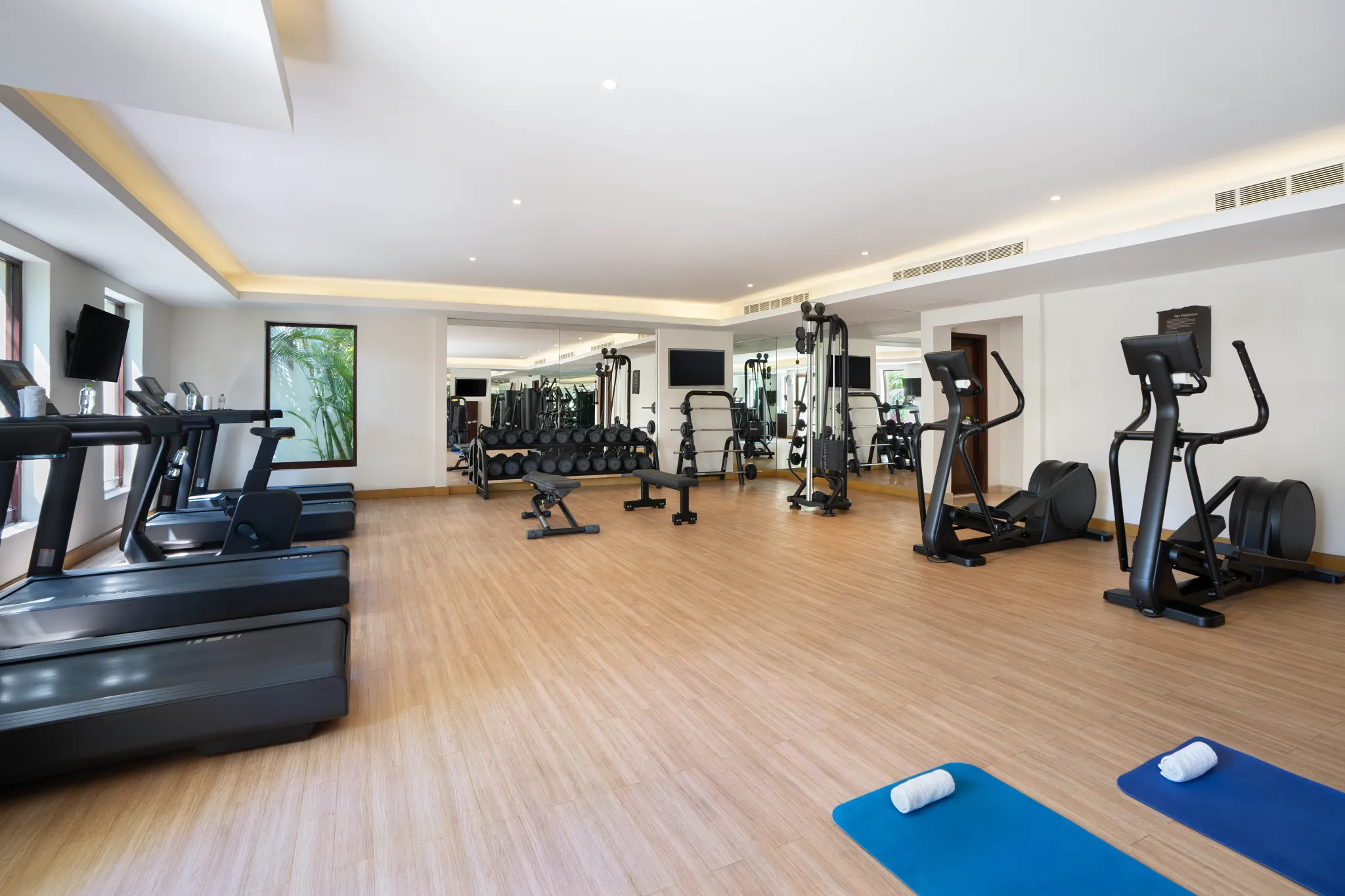 Modern fitness center with cardio and weight equipment at Secrets Puerto Los Cabos resort.