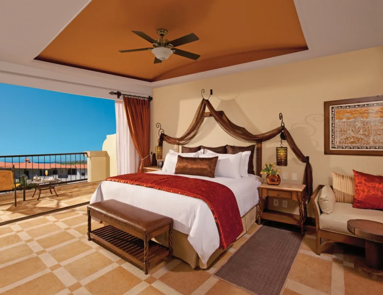 Junior Suite Garden View with king bed and private balcony at Secrets Puerto Los Cabos Golf & Spa Resort overlooking lush grounds.