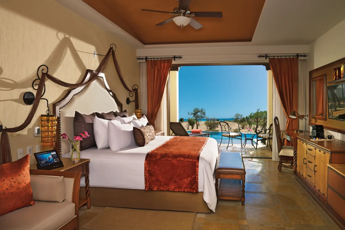 Junior Suite Swim Out Ocean View with king bed and terrace leading to pool at Secrets Puerto Los Cabos Resort.