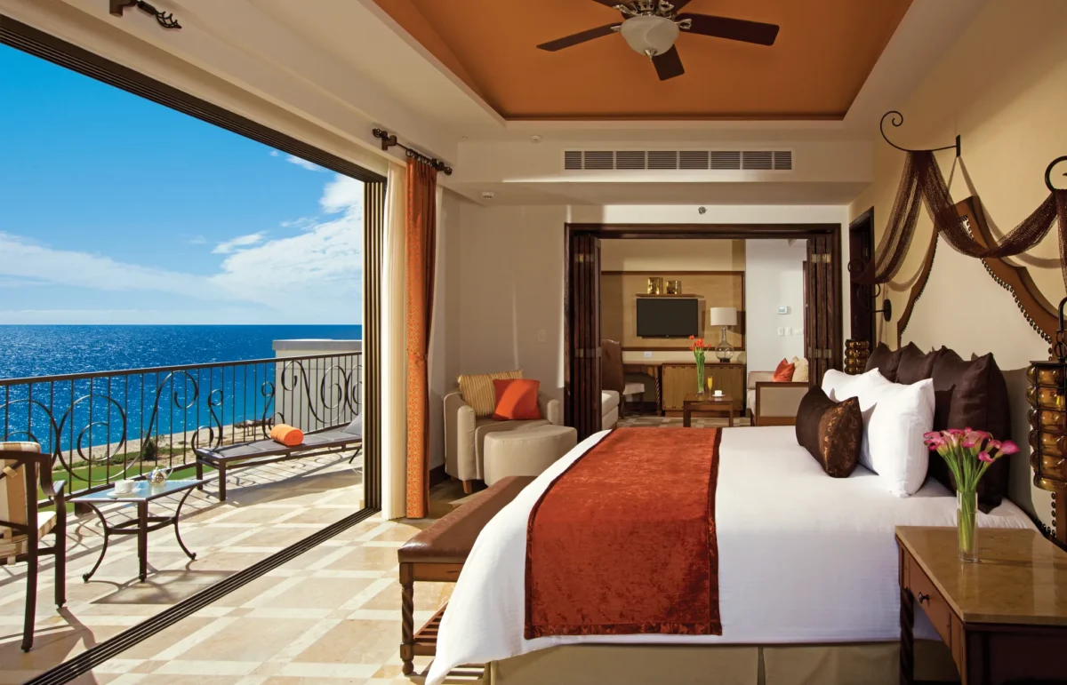 Master Suite Ocean Front bedroom with king bed and oceanview balcony at Secrets Puerto Los Cabos Golf & Spa Resort.