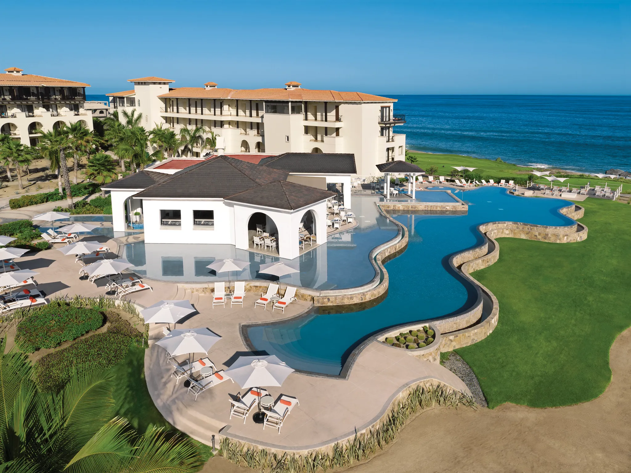 Resort pool complex with swim-up areas overlooking the Sea of Cortez at Secrets Puerto Los Cabos.