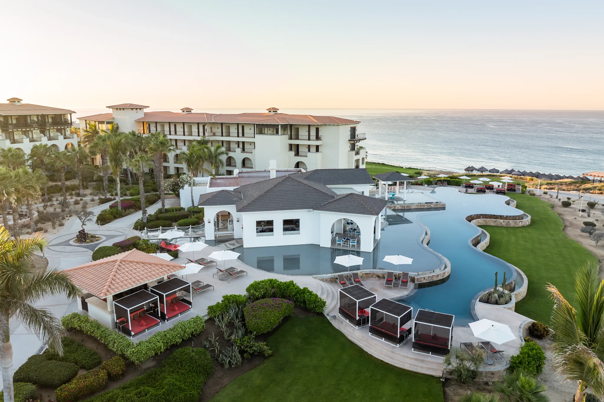Exclusive Preferred Club pool with cabanas at Secrets Puerto Los Cabos Golf & Spa Resort overlooking the ocean.